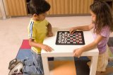 Portrait of Hispanic boy and girl playing checkers