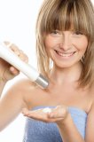 Woman with bottle of body lotion