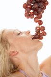 Young woman eating red table grapes