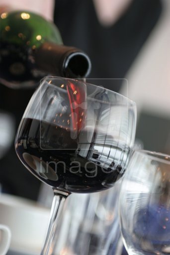 Red Wine being poured in to a glass in a restaurant. Close crop.