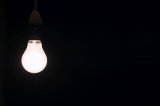 Shining lightbulb against black background