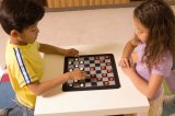Portrait of Hispanic boy and girl playing checkers