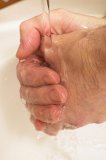 Man washing hands turning tap