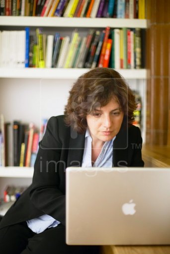 business woman sittiing on stairs working from home on laptop