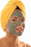 Woman with towel around her head wearing mud mask