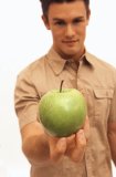 Caucasian male holding a green apple.