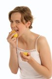Teenage woman eating lemon