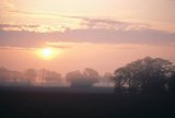 Dawn over misty rural landscape
