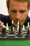 Unclose portrait of a man playing chess.
