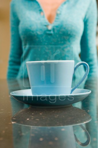 Artistic portrait of woman behind cup