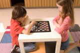 Portrait of Asian boy and Caucasian girl playing checkers