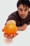 Portrait of a Hispanic male holding a orange.