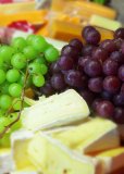 green and red grapes with cheeses: food eat dinner diner end of meal board restaurant cook chef cuisine fruit cheese selection 