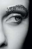 Section of a woman's face with a diamond encrusted eye and eyebrow