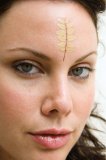 Upclose portrait of woman with leaves on forehead.