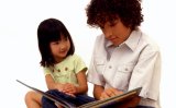 Young boy reading a story to young girl.