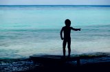 Small Boy Silhouetted on Beach